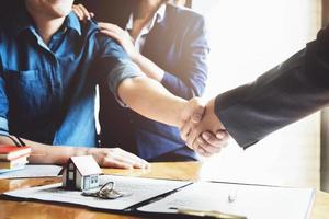 Focus on the congratulatory handshake. The real estate agent agrees to buy the home the customer at the agent's office. concept agreement. photo