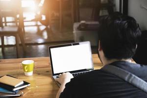 freelance concept, man using computers  laptop on wooden desk blur background. Laptop computer with blank screen and can be add your texts or others on screen. photo