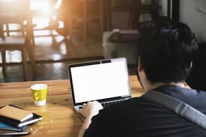 freelance concept, man using computers  laptop on wooden desk blur background. Laptop computer with blank screen and can be add your texts or others on screen. photo