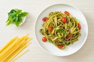 fettuccine spaghetti pasta with pesto sauce and tomatoes photo