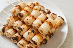 grilled tube shaped fish paste cake skewe or tube squid skewer photo