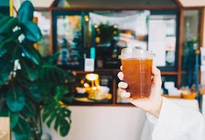 hand holding iced americano coffee glass photo