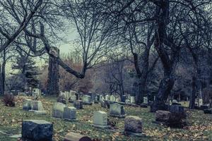 Detrás de las lápidas en un antiguo cementerio en otoño foto