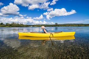 Río tranquilo y mujer relajante en un kayak foto