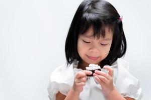Child girl enjoy eating Christmas Sweets cake. Happy time. On white background. photo