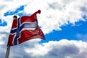 La bandera nacional de Noruega en el cielo azul de viento áspero. foto