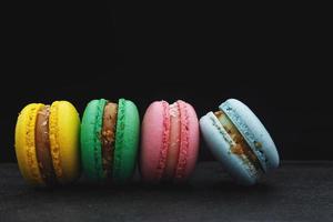 four multi-colored homemade natural products macaroon on a black background