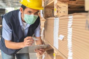 Trabajador comprobando el inventario de materias primas en la fábrica. foto