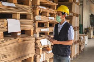 Trabajador comprobando el inventario de materias primas en la fábrica. foto