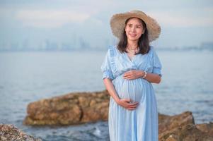 mujer embarazada viajando al mar feliz