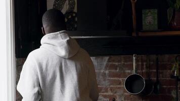 Man standing in kitchen looking for something video