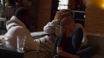 Boy sitting between man and woman on couch watching television video