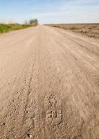 paso de pie en un polvoriento camino rural foto