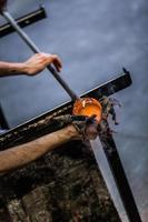 Man Hands Closeup Working on a Blown Glass Piece photo