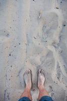 Men's barefoot feet in the sand photo