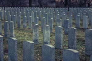 Back of Army Headstone and Graveyard Cemetery during a Sad Day of Autumn. photo