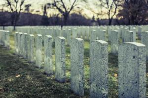 Back of Army Headstone and Graveyard Cemetery during a Sad Day of Autumn. photo