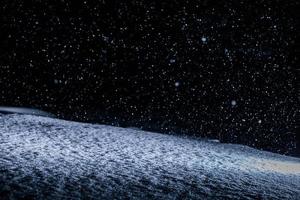 Textura de nieve retroiluminada durante la tormenta de nieve por la noche foto