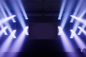Focos de escenario con pantalla en blanco en el medio.