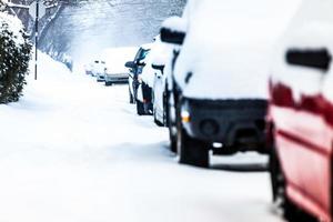 Autos estacionados en un día de invierno con tormenta de nieve foto