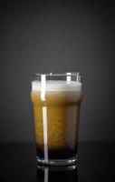 Draft Nitrogen Fresh and Creamy Black Stout Beer Pint over Black Background photo