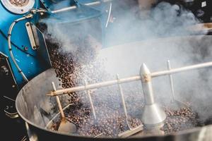 Roasted coffee beans steaming in cooling cylinder photo