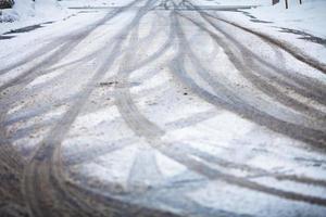 camino cubierto de nieve, las marcas de las ruedas foto