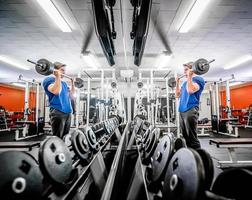 hombre en gimnasio con barra foto