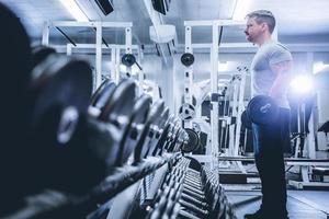 Bodybuilder lifting barbell in gym.