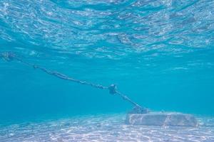 Anclaje de hormigón y cuerda vieja vista desde el submarino en el océano caribe.