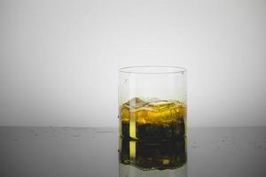 Splashing Glass of Single Malt Whisky over Gray Background photo