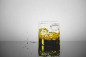 Splashing Glass of Single Malt Whisky over Gray Background photo