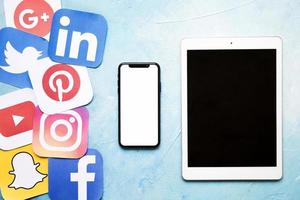 iconos de redes sociales con teléfono móvil tableta digital pared pintada de azul foto