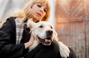 blond woman hugging her retriever dog photo