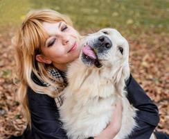 blond woman hugging her retriever dog photo