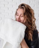 beautiful woman smelling clean clothes at home photo