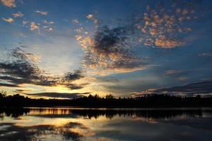 Romantic sunset with unique reflections on a peaceful lake photo