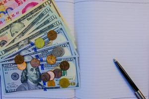 Empty blank notebook with colorful international banknotes and calculator.Management income and  saving concept. photo