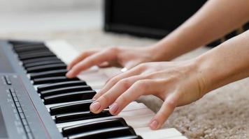 Cerrar músico femenino tocando el teclado del piano