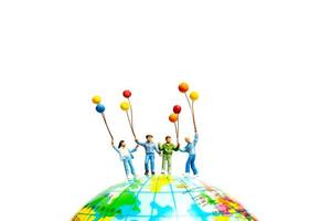 Miniature people , Childrens holding balloons standing on the globe photo