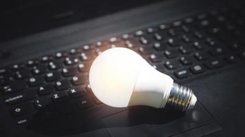 Light bulb on laptop keyboard. Idea, innovation, creativity photo