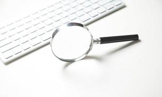 Magnifier with computer keyboard. Searching internet photo