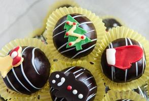 bolas de chocolate árbol de navidad muñeco de nieve ciervos. foto