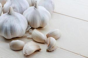 Organic garlic whole and cloves on the wooden background photo