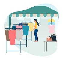 Woman buying clothes at street market flat vector illustration. Trade tent, fair awning. Buyer at outdoor local clothing store, shop cartoon character. Market tent with second hand clothes racks