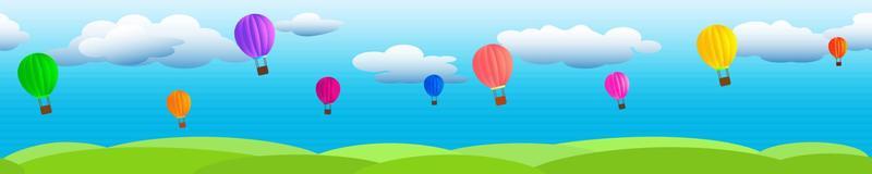 Clouds on a blue sky with flying balloons and green grass.