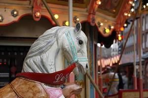 carrusel de caballos y linternas de feria en el mercado navideño. foto