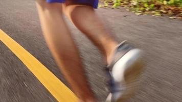 corridori che corrono sul sentiero stradale nell'allenamento mattutino per la maratona e il fitness. concetto di stile di vita sano. atleta in esecuzione che si esercita all'aperto. primo piano delle gambe. video