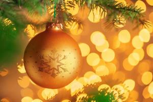 Christmas tree background with golden bauble on bokeh sparkling photo