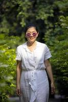 asian woman wearing white dress standing in green park photo
